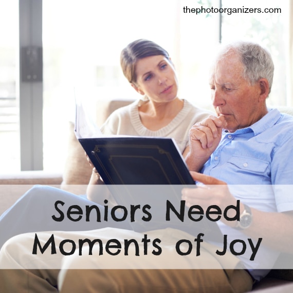 A senior man and his daughter looking at old family photos at the nursing home
